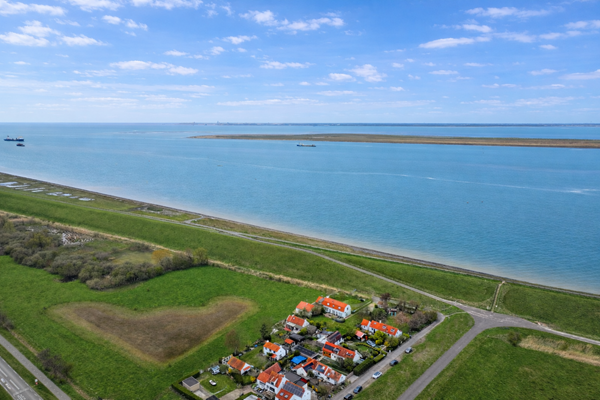 Kustdorp met rode daken en zee.png